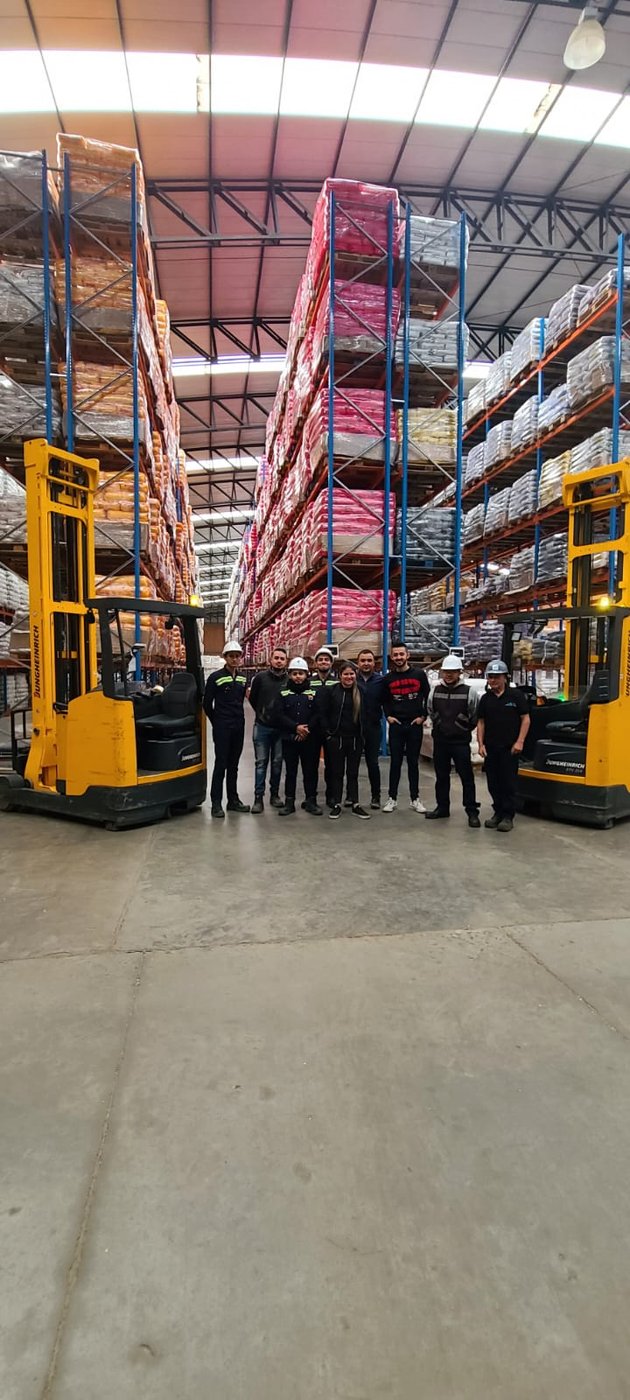 Equipo operativo Tractocar en bodega con montacargas